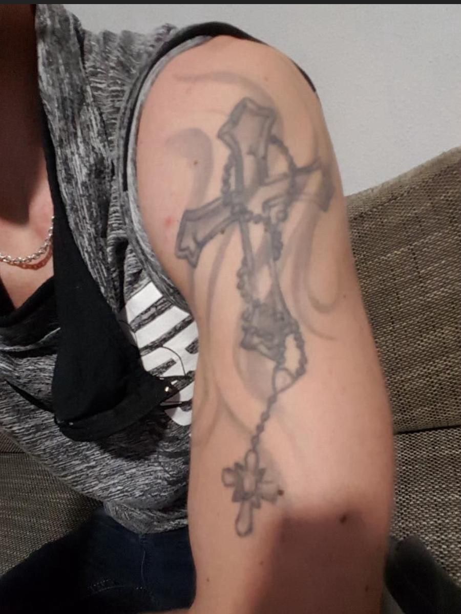 Vorher: verblasstes Kreuz-Tattoo am Oberarm